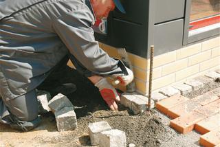 Układanie obramowania od strony budynku w postaci kostek granitowych