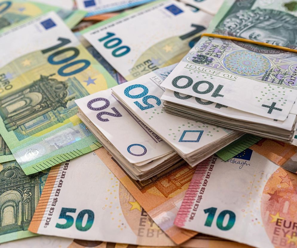 Rozrzucone banknoty euro i pln, w tym sto złotych spięte gumką, leżące na stosie. Przedstawia symbolicznie kursy walut, o których przeczytasz więcej na Super Biznes.