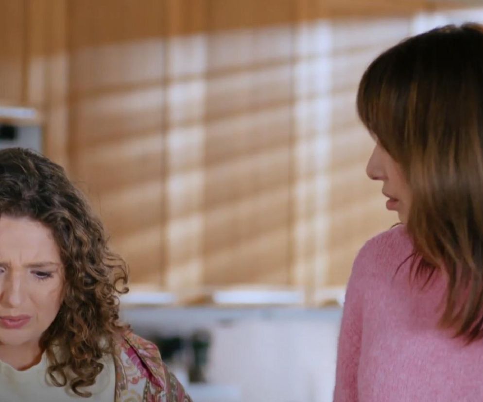 Ciężarna Ada (Nikola Czarniecka) ze skrzywioną z bólu twarzą i Basia (Grażyna Wolszczak) w różowym swetrze, patrząca na nią z troską. Scena z serialu Na Wspólnej, gdzie Ada zaczyna rodzić. Więcej o losach bohaterów przeczytasz na Super Seriale.