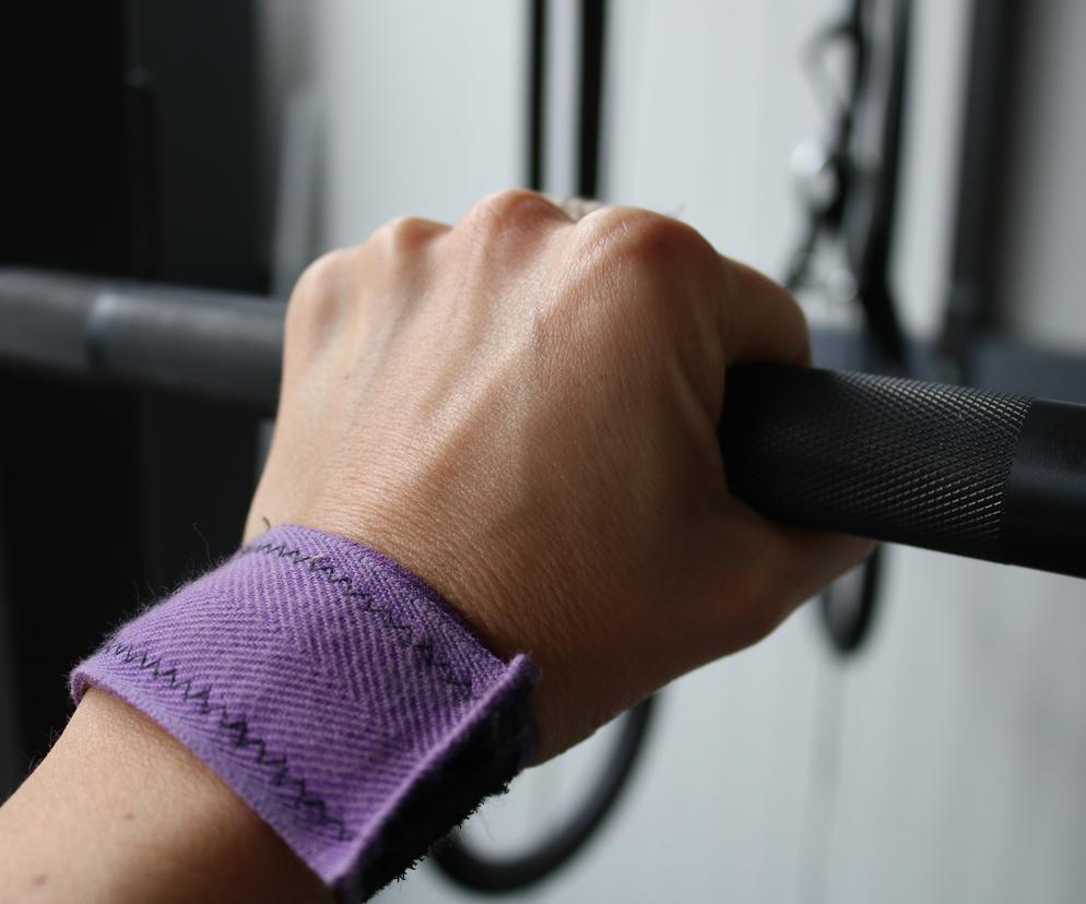 Kobieta trzymająca sztangę na siłowni