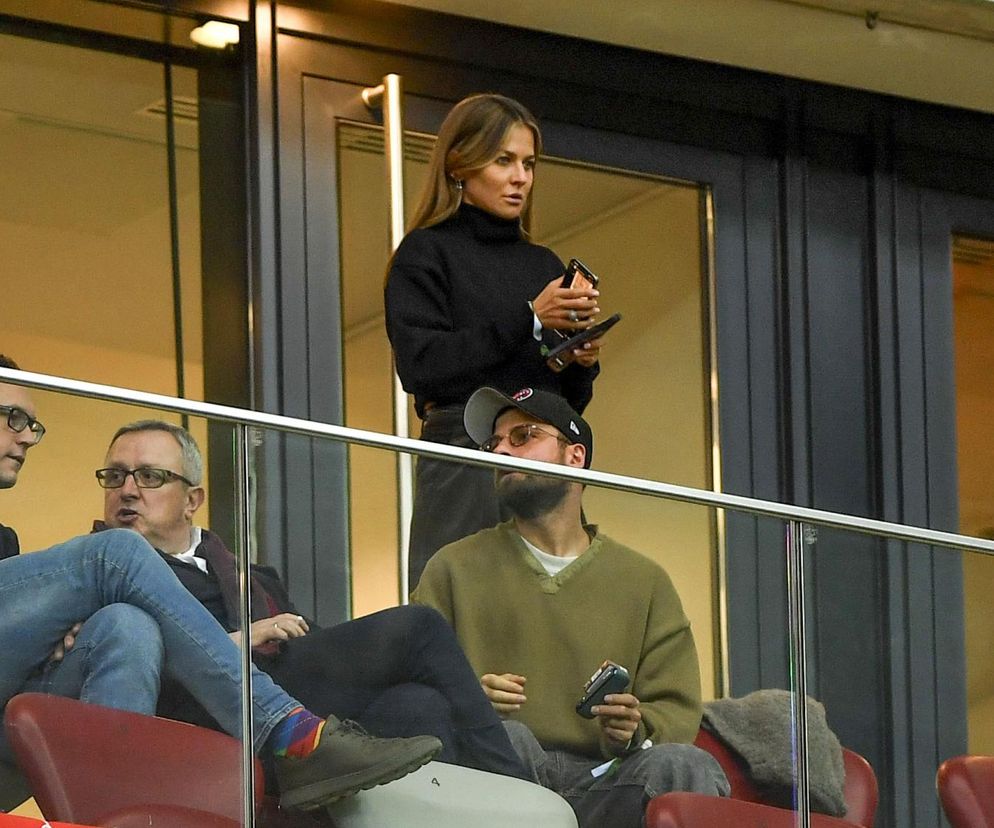 Anna Lewandowska stoi w loży na stadionie i trzyma telefon. O jej odpowiedzi na krytykę przeczytasz na SE.