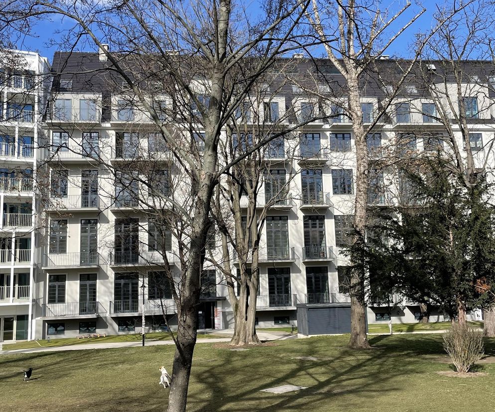 Zrewitalizowany budynek mieszkalno-usługowy B3 przy pl. Jana Pawła II 8 we Wrocławiu, z charakterystycznymi balkonami i dachem dwuspadowym, będący częścią dawnego kompleksu szpitalnego. Zdjęcie przedstawia architekturę nawiązującą do wrocławskiego modernizmu, o której więcej przeczytać można na Architektura Murator Plus.