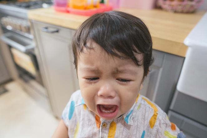 płaczące dziecko stojące w kuchni