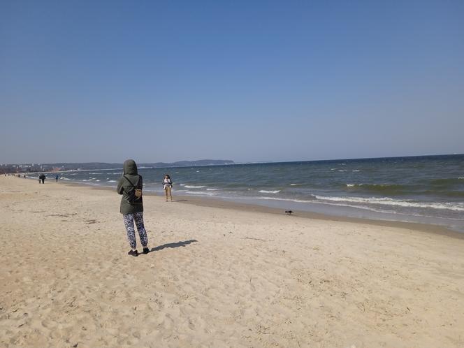 Mieszkańcy korzystają ze słonecznej pogody. Na plaży w Jelitkowie widać już pierwszych spacerowiczów!