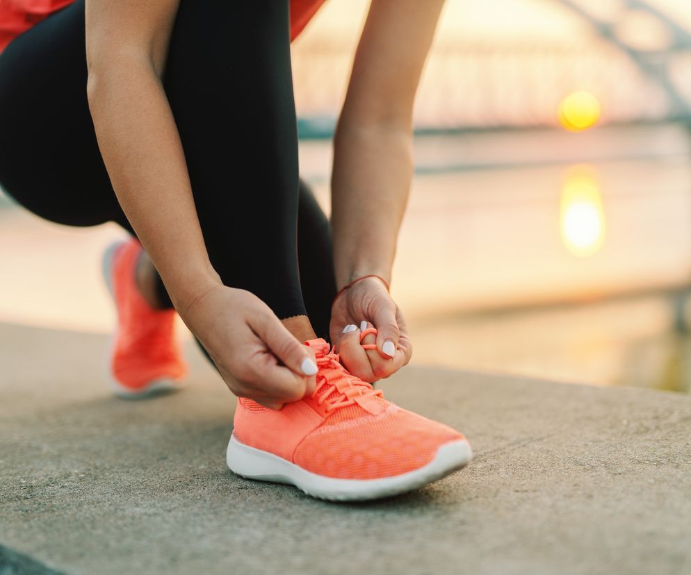 Kobieta sznuruje buty do biegania