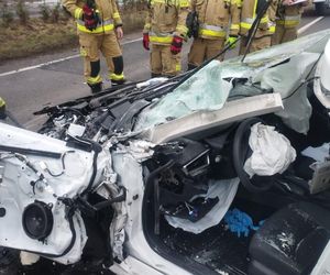 Tragiczny wypadek pod Lesznem. Przód osobówki został kompletnie zmiażdżony. Strażacy wycinali z wraku poszkodowaną