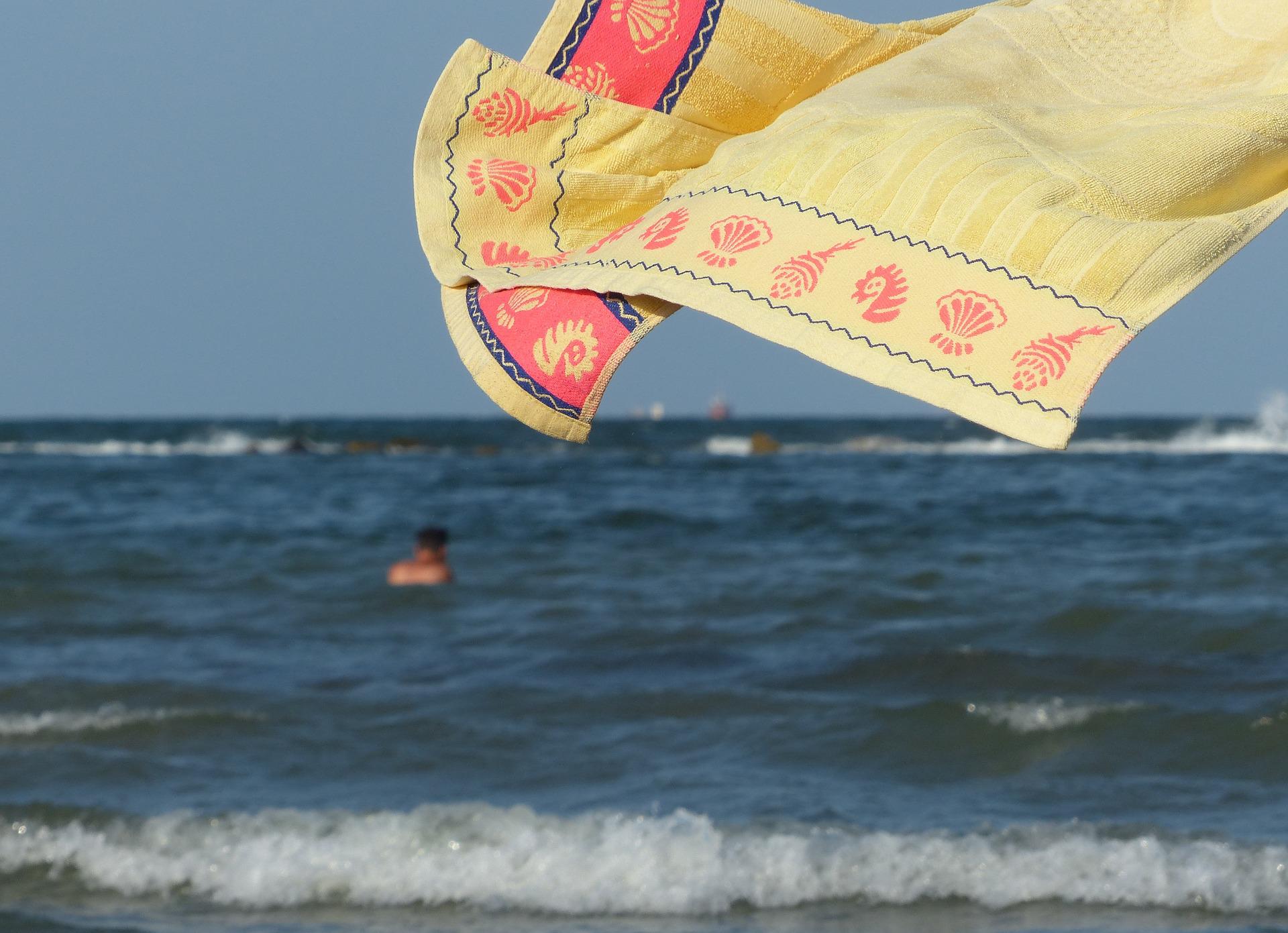 Полотенцем солнцем. Полотенце на ветру. Летающее полотенце. Полотенце на море. Мешки на пляже моря.