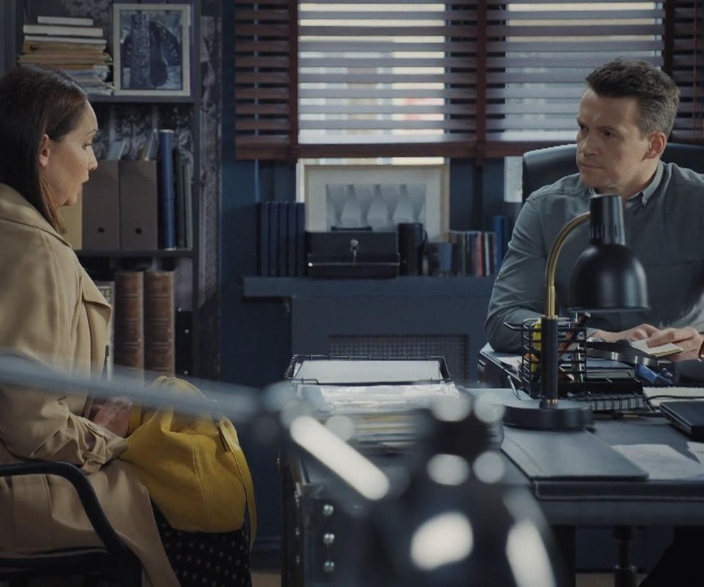 Nowa klientka Barbara Kubrak w biurze detektywistycznym Jakuba Karskiego Krzysztofa Kwiatkowskiego, opowiada mu o swoich podejrzeniach dotyczących spisku rodzinnego w 1884 odcinku serialu M jak miłość. W tle widać zasłonięte okno i regał z dokumentami. Więcej o Super Seriale przeczytasz na naszym portalu.