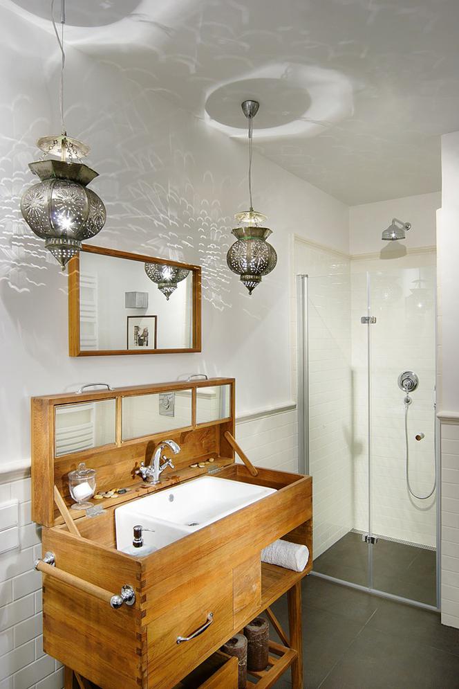 Stylowa łazienka z oryginalną obudową umywalki.