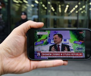 Zbigniew ZIobro udziela wywiadu w TV Republika. W tle budynek parlamentu