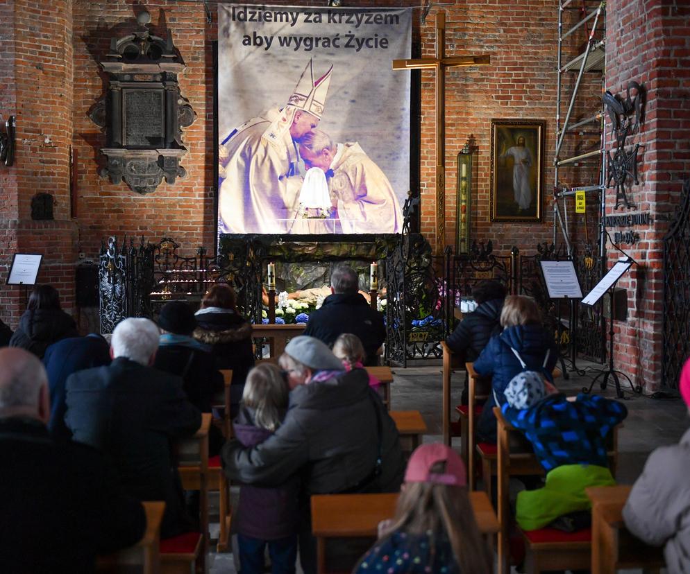 Archiwalne zdjęcia Jana Pawła II w Bazylice św. Brygidy w Gdańsku. Fotografie pojawiły się przy Grobie Pańskim