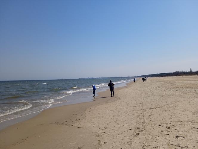 Mieszkańcy korzystają ze słonecznej pogody. Na plaży w Jelitkowie widać już pierwszych spacerowiczów!