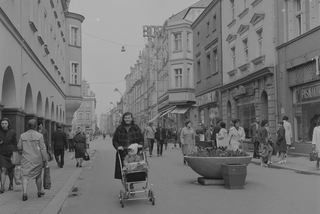 Widoczne zabytkowe kamienice. Na ulicy kobieta z dzieckiem w wózku, 1973-05-11 