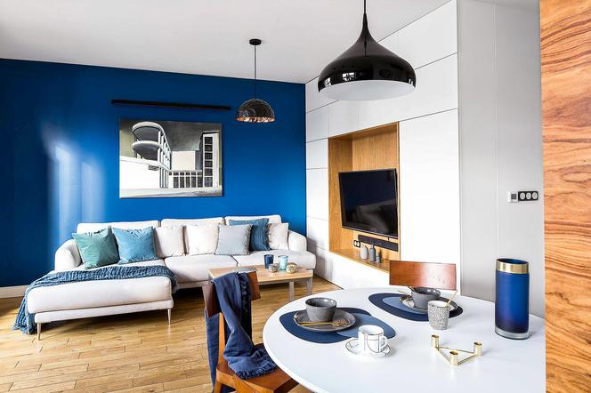 Nowoczesne mieszkanie, 63 m2. Niebieska ściana w salonie budzi zachwyt gości