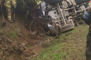 Dachowanie ciężarówki z drewnem. Kierowca został uwięziony w kabinie