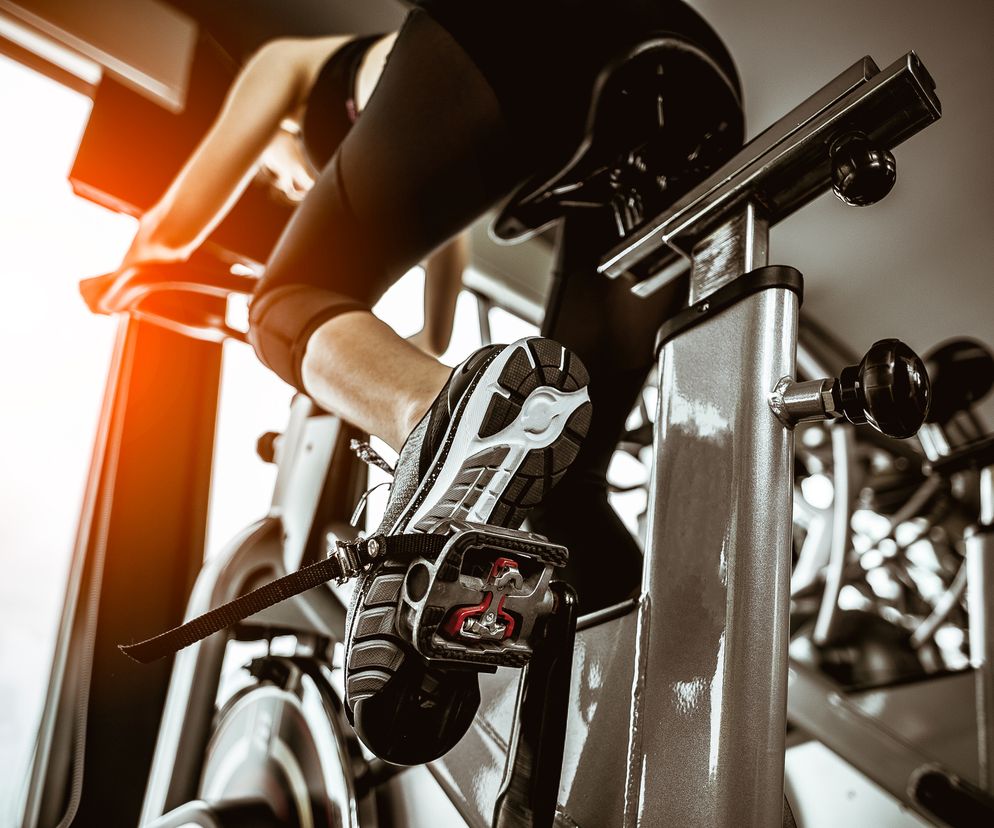 Kobieta trenuje na rowerku stacjonarnym