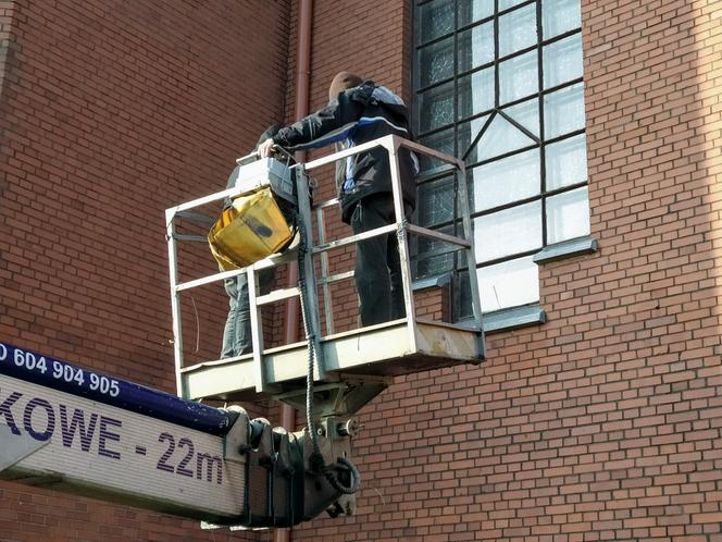 Policjanci zabezpieczający ślady na miejscu zdarzenia, pracują na wysięgniku