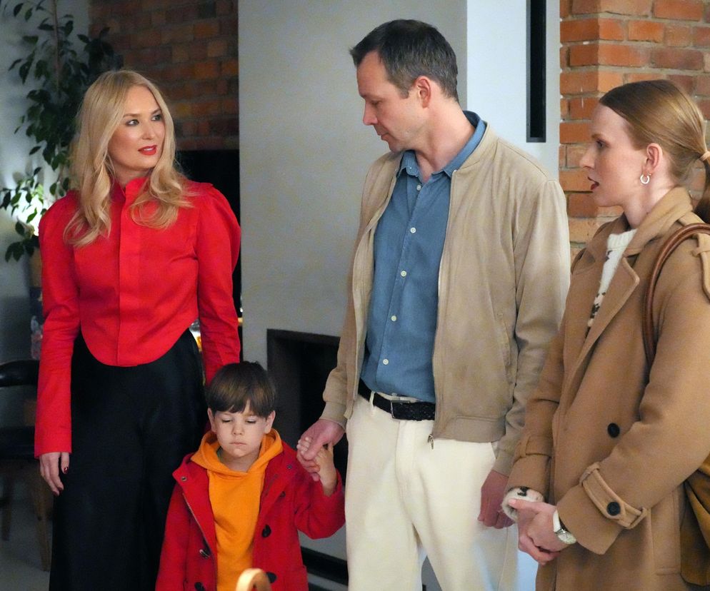 Karolina (Marta Dąbrowska) w czerwonej bluzce i czarnej spódnicy, Bruno (Lesław Żurek) w jasnej kurtce i jeansowej koszuli, trzymający za rękę Tadzia w czerwonej kurtce oraz kuratorka Jagoda (Karolina Rzepa) w beżowym płaszczu. Możesz przeczytać więcej o ich losach na Super Seriale.