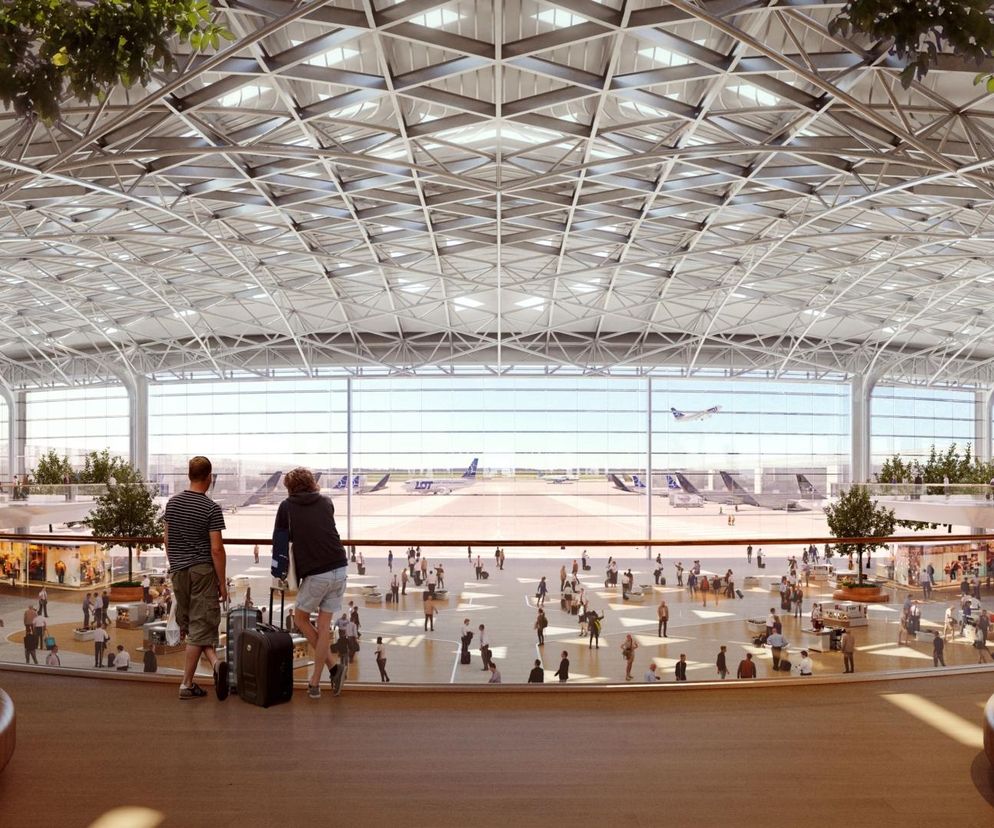 Wizualizacja nowoczesnego terminala CPK z dużą, przeszkloną fasadą i widokiem na płyty lotniska z samolotami LOT. Wnętrze z naturalnym światłem, ozdobne drzewa, liczne osoby i punkty usługowe. Więcej o architekturze na portalu Architektura Murator Plus.