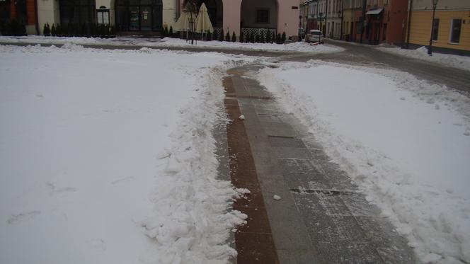 Rynek w Tarnowie pod śniegiem. W akcji pługopiaskarka MPGK