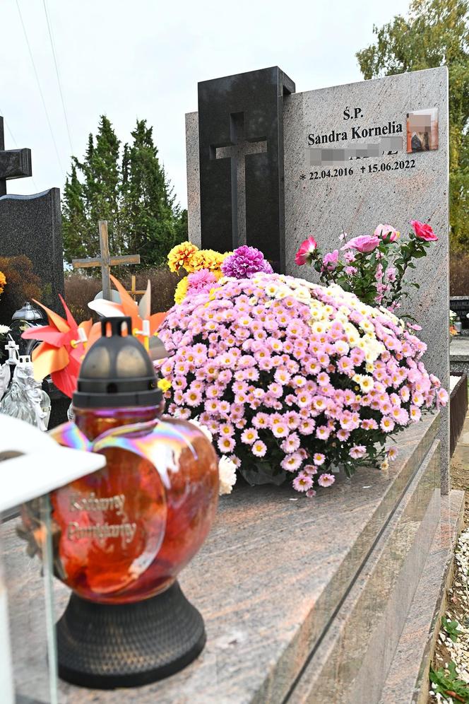 Aniołki i misie strzegą grobu 6-letniej Sandry, obok rozkwita kwiat róży