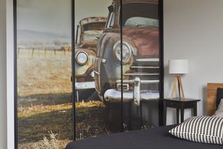 Szara sypialnia na poddaszu: minimalistyczny projekt sypialni z fototapetą. Jak to pogodzić?