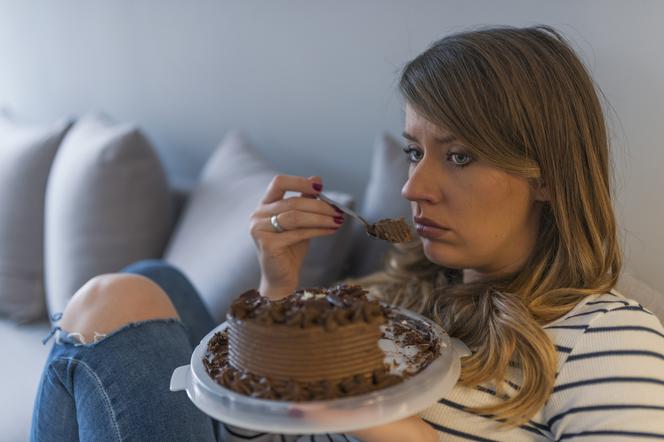 Młoda kobieta spożywająca kawałek tortu czekoladowego 