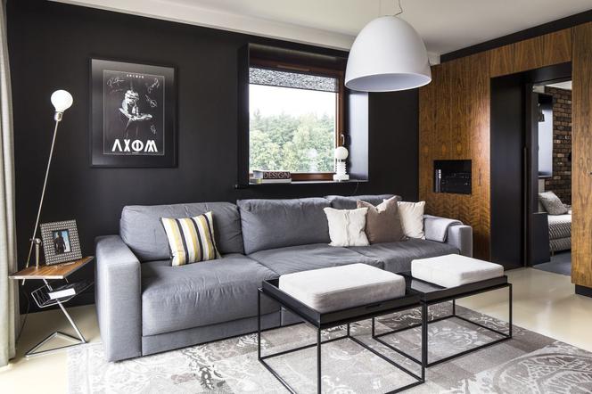 Stylowy salon z czarną ścianą i drewnem: nowoczesna aranżacja wnętrza 
