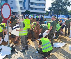 ieszkańcy w pocie czoła układają worki z piaskiem i zabezpieczają swoje budynki