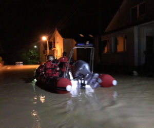 Wóz strażacki z rodziną pod wodą