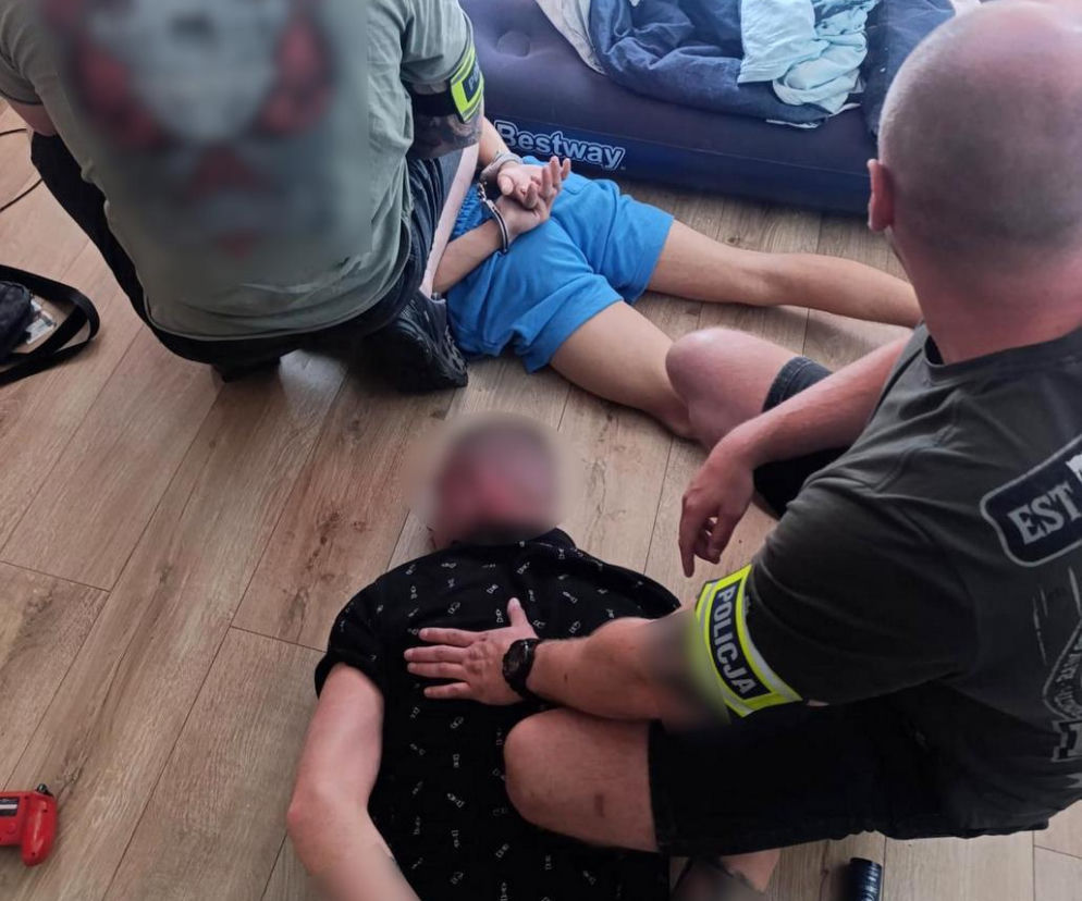 Policjanci zatrzymują dwóch mężczyzn, którzy leżą na podłodze z kajdankami na rękach, w tle widać dmuchany materac Bestway. Funkcjonariusze rozbili narkotykowy magazyn w Bydgoszczy, o czym przeczytasz więcej na naszym portalu.