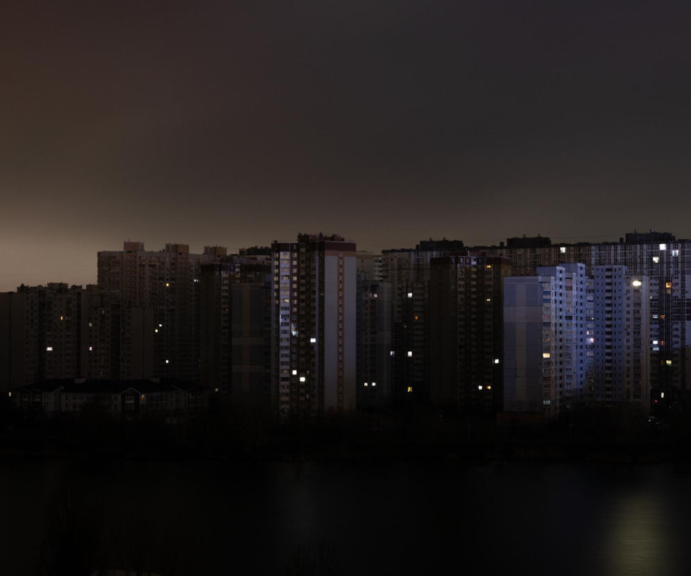 Blokowisko nocą, większość okien ciemna, tylko nieliczne świecą się w blokach po zapadnięciu zmroku, co symbolizuje blackout i brak prądu. Zdjęcie ilustruje temat kryzysu energetycznego, o którym przeczytasz na Super Biznes.