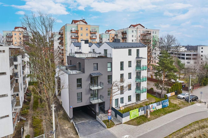 Nowoczesny biało-szary budynek wielorodzinny na Białołęce. O nowych inwestycjach PRK7 przeczytasz na Muratorplus.