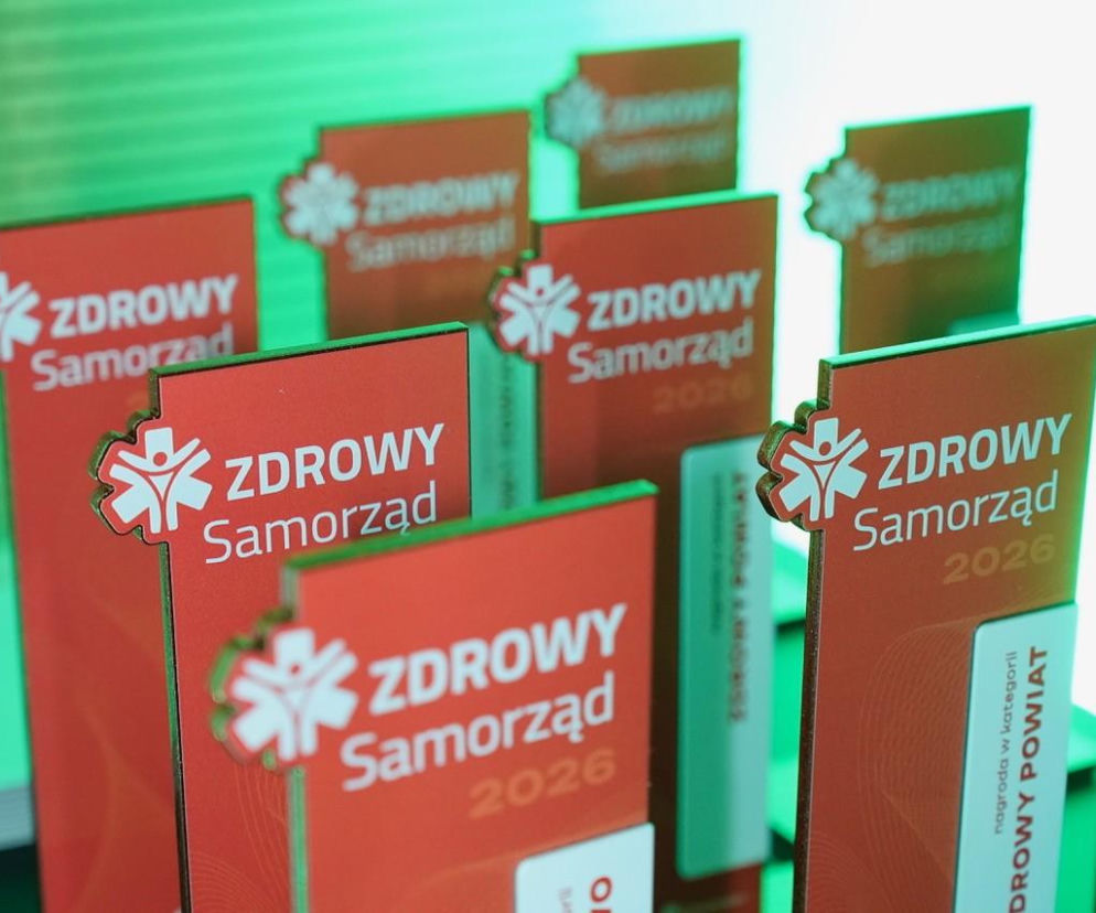 Statuetki Zdrowy Samorząd 2026, z logo przedstawiającym symbol ludzi w kole, widoczne podczas gali rozdania nagród. Są to nagrody w konkursie promującym najlepsze praktyki w zakresie promocji zdrowia, o którym można przeczytać na portalu Poradnik Zdrowie.