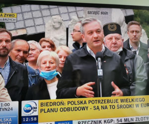 Robert Biedroń na tle religijnego hasła