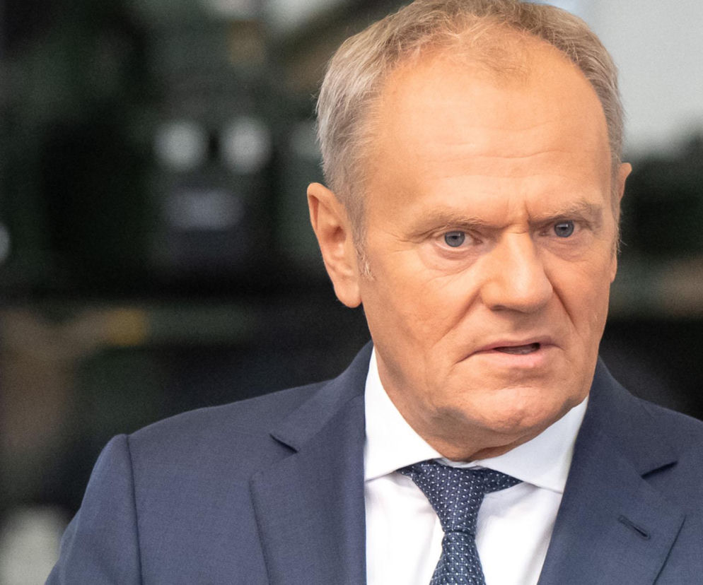 Premier Donald Tusk w marynarce i krawacie z przejętą miną. O oskarżeniach PiS i aferze Zondacrypto przeczytasz na Eska.