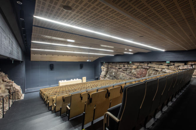 Wnętrze sali audytoryjnej osadzonej w blokach skalnych