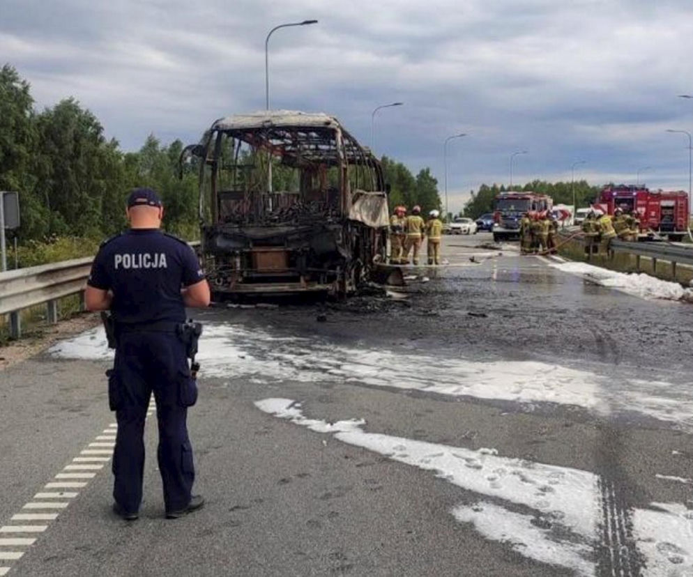 Policjant i strażacy przy wraku spalonego autokaru na węźle A1. O pożarze przeczytasz na Eska Śląskie.