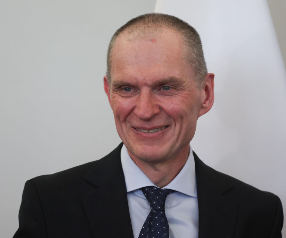 Uśmiechnięty Andrzej Poczobut w ciemnym garniturze i krawacie. O jego decyzji o powrocie na Białoruś przeczytasz na SE.