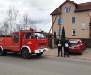 Strażacy z OSP dostarczają ulotki na temat szczepień do mieszkańców powiatu iławskiego