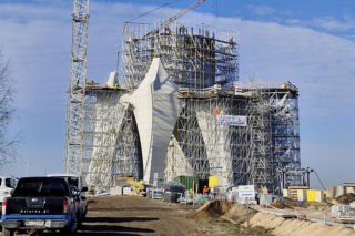 Budowa pomnika Matki Boskiej pod Kikołem daleko w polu. Na tablicy termin ukończenia, za dwa miesiące!