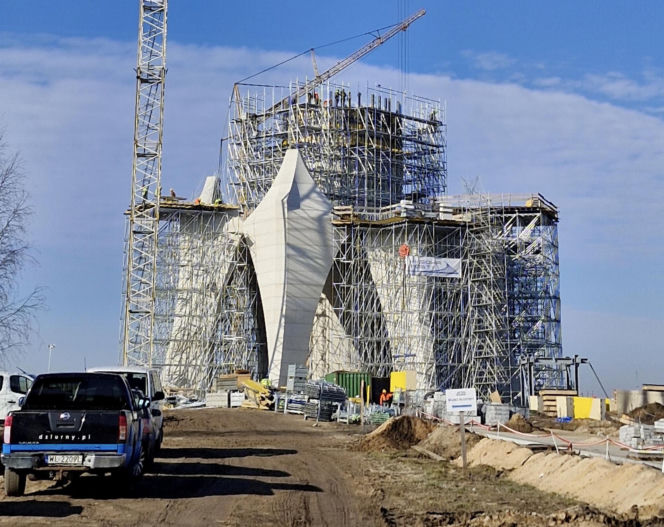 Budowa pomnika Matki Boskiej pod Kikołem daleko w polu. Na tablicy termin ukończenia, za dwa miesiące!