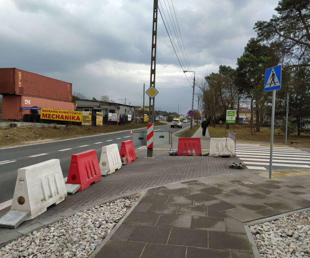 Energetyczny słup na środku wjazdu do sklepu. Ludzie robią sobie przy nim zdjęcia