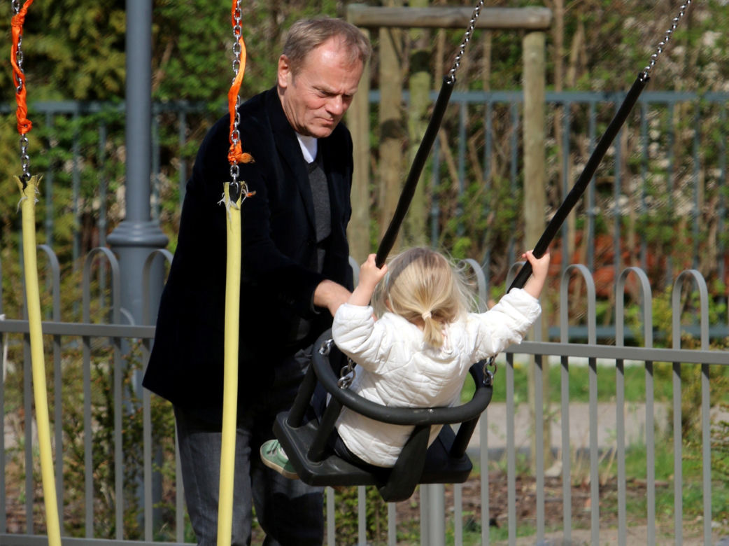 Donald Tusk z wnuczka na placu zabaw