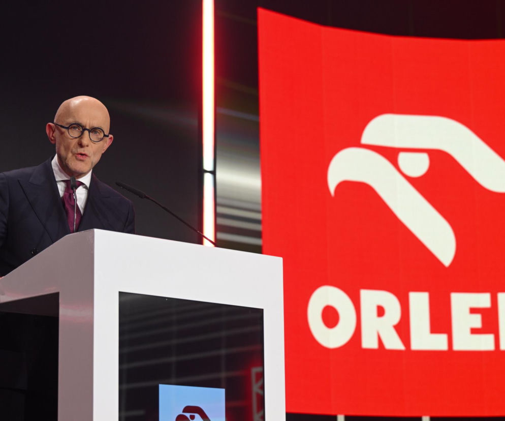 Prezes zarządu ORLEN, Ireneusz Fąfara, podczas prezentacji planów koncernu, stojący za mównicą, z dużym logo ORLEN w tle. Zdjęcie ilustruje aktualne wydarzenia gospodarcze, o których można przeczytać na Super Biznes.