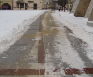 Rynek w Tarnowie pod śniegiem. W akcji pługopiaskarka MPGK