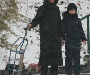 Marta Kaczyńska z synem i psami na sankach w lesie