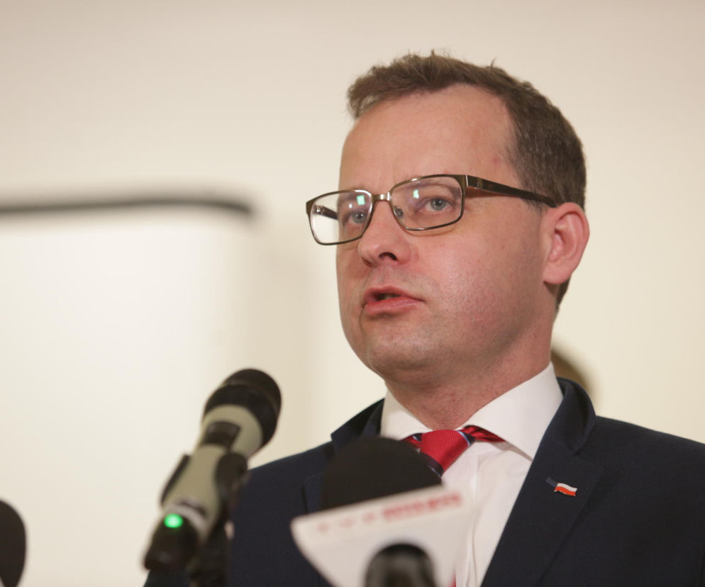 Marcin Romanowski w okularach przemawia do mikrofonów. O poszukiwaniach polityka przeczytasz na SE Polityka.