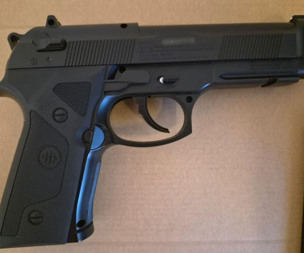 Czarny pistolet pneumatyczny leżący na jasnym tle. O strzelaninie w Garwolinie przeczytasz na SE.