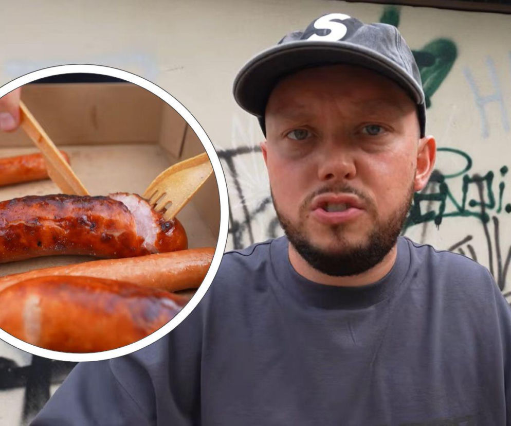 Szymon Nyczke, znany jako Książulo, w czapce z daszkiem i koszulce, z zaciętą miną na tle ściany pokrytej graffiti. W okręgu, na pierwszym planie, widać kiełbasy Skolima w tekturowym pudełku, z których jedna jest przekrojona i nabierana drewnianym widelcem. Więcej o ocenach produktów celebrytów przeczytasz na naszym portalu.